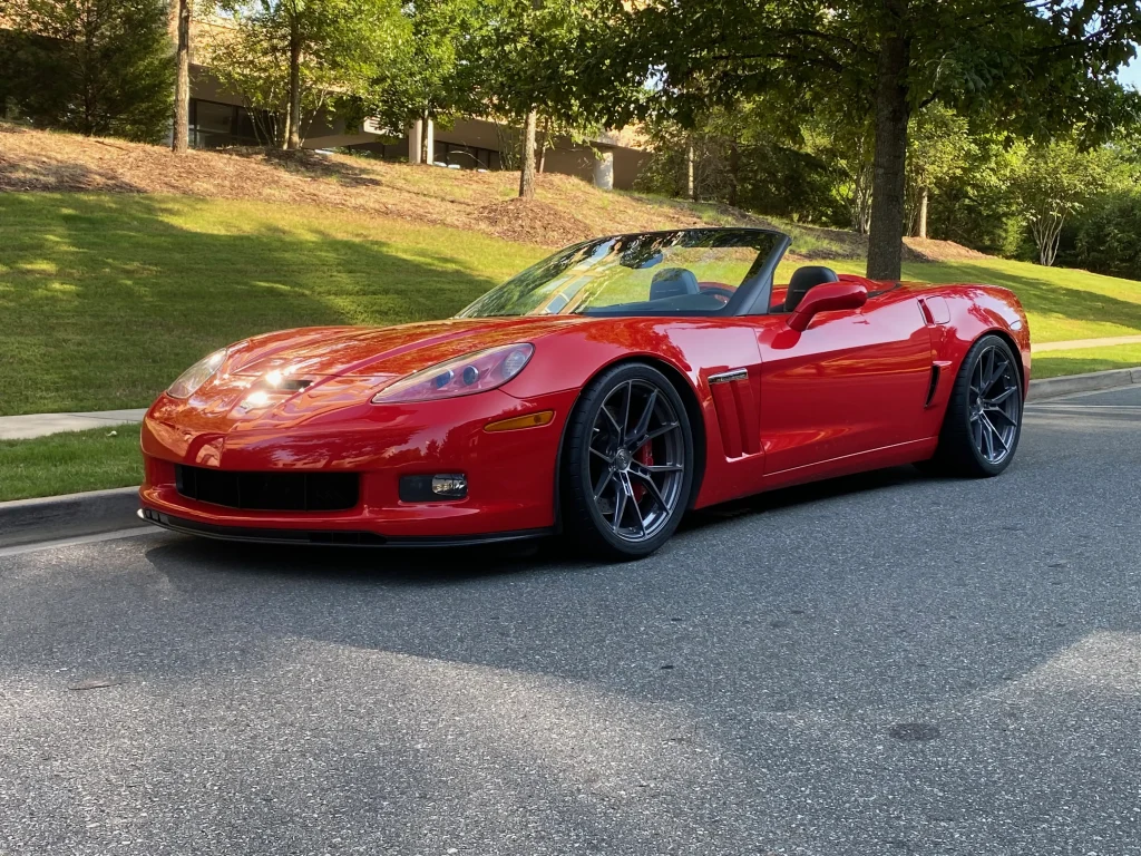 Red C6 Corvette showcasing aftermarket E5 custom wheels from the side